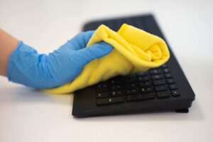 empregada de limpeza limpando o escritório com um pano de microfibra
